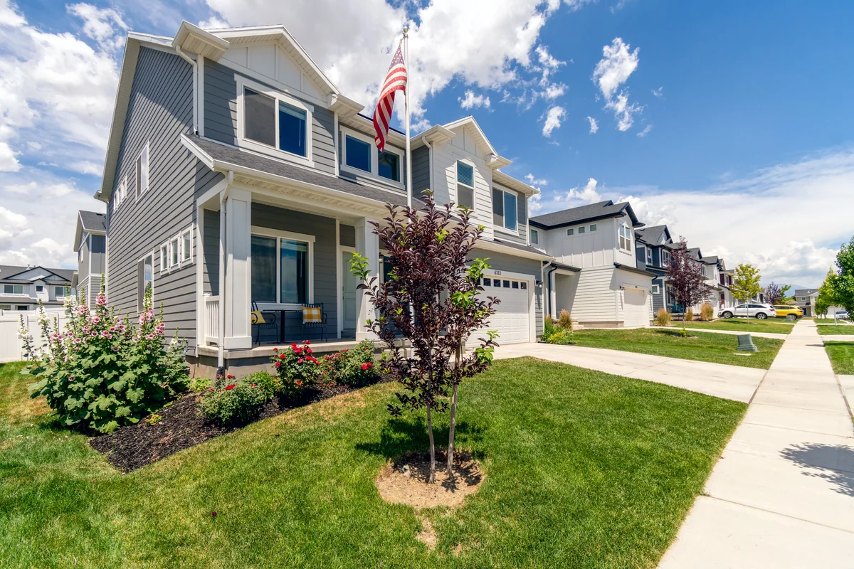 Row of contemporary suburban homes with front lawns and porches.
