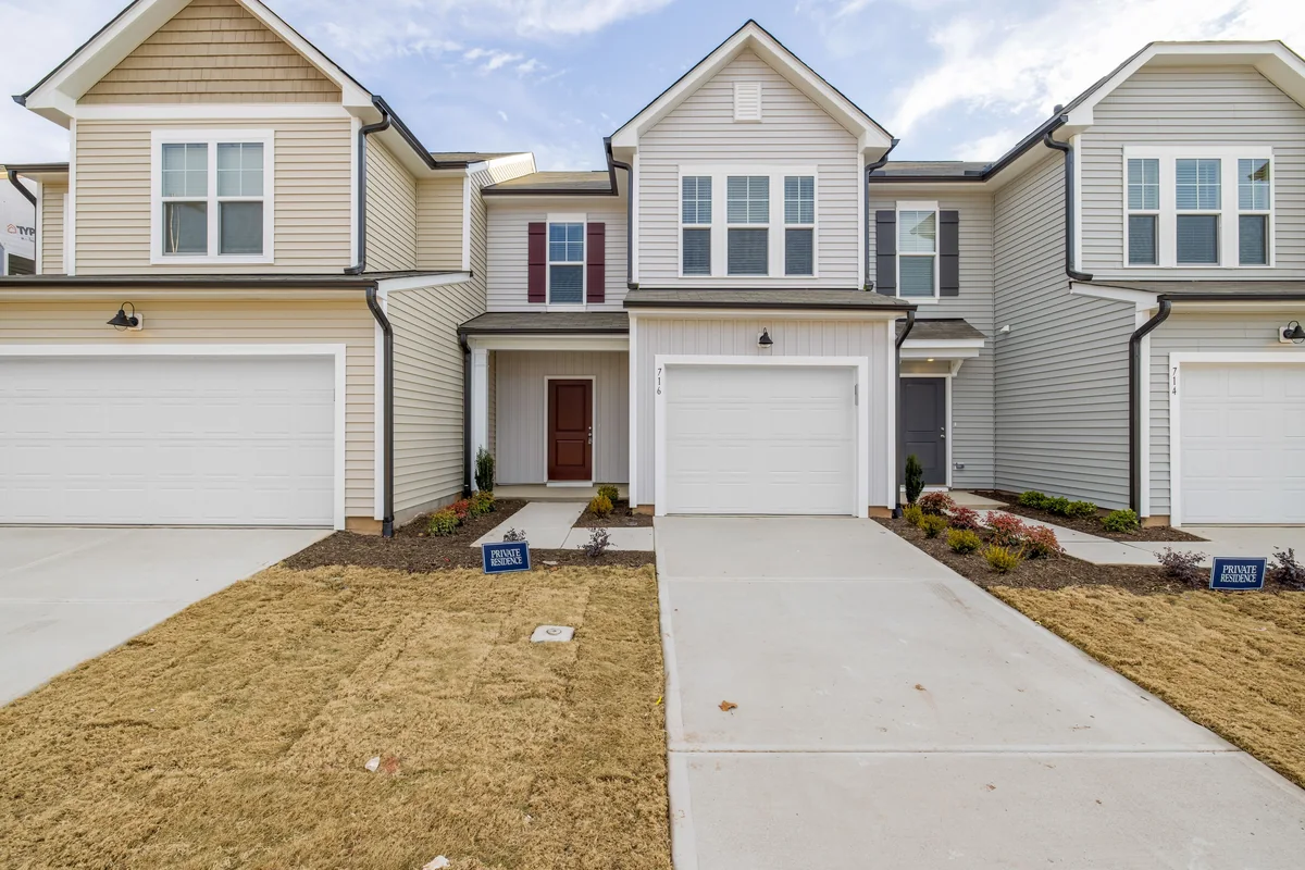 Two-story attached homes with separate driveways and garage doors.