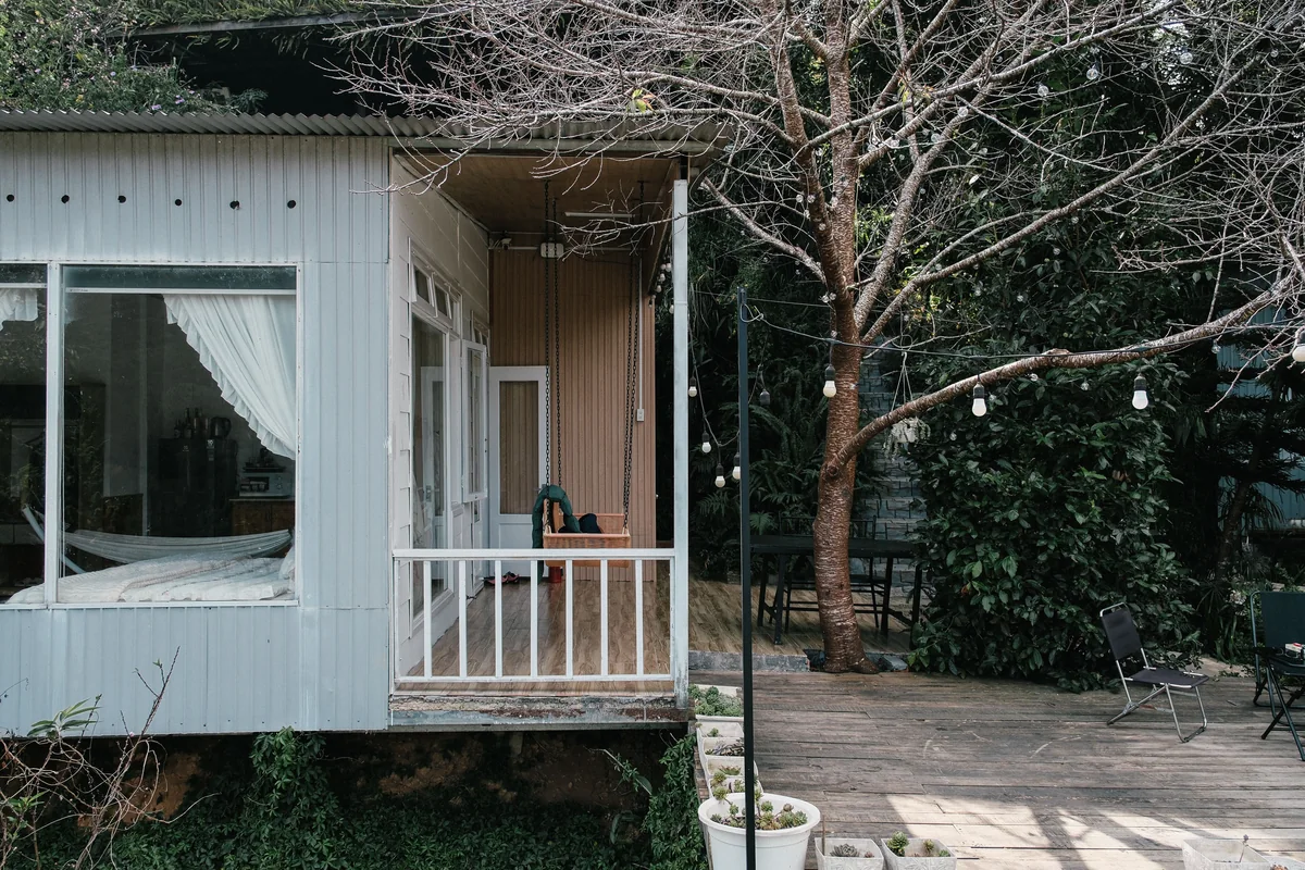 Small country house with an outdoor deck and a leafless tree.