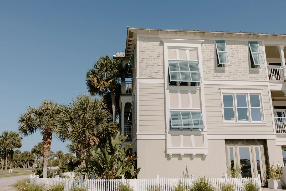 Multistory residential building with light siding and shuttered windows.